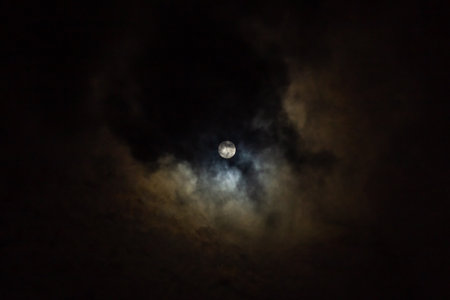Full moon in the night sky with clouds and stars in the backgroundの写真素材