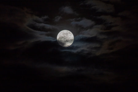 Full moon in the night sky with clouds, natural background photo.の写真素材