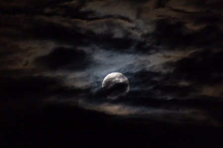 Full moon in the night sky with dark clouds, closeup of photoの写真素材