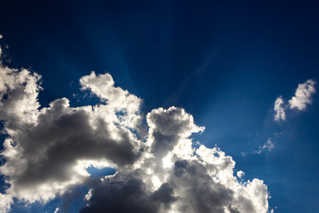 Blue sky with white clouds and sunbeams. Nature background.の写真素材