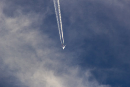 Airplane in the blue sky with white clouds, close-upの写真素材
