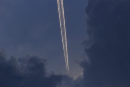 Airplane trail in the sky with clouds