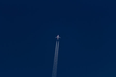 Airplane in the blue sky with a trace of the plane.