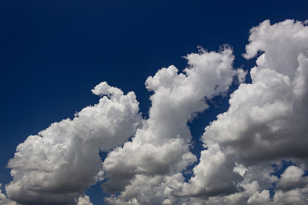 Blue sky background with white clouds. Cumulus white clouds in the blue sky.