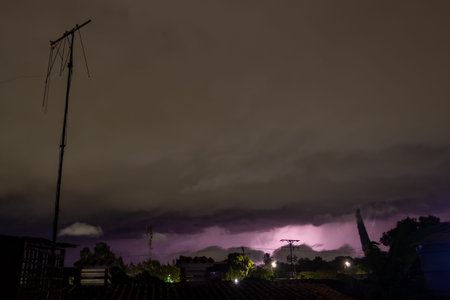 Lightning in the sky at night with rain and thundercloud.