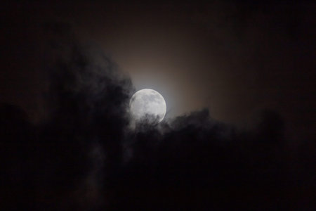 Full moon in the night sky with clouds, closeup of photo