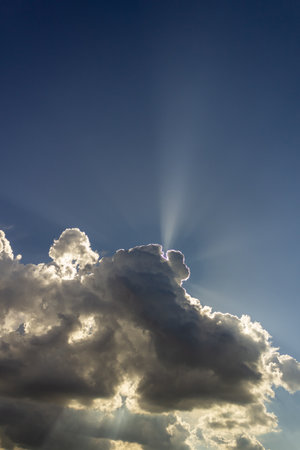 Clouds in the blue sky with sun rays and lens flare.の写真素材