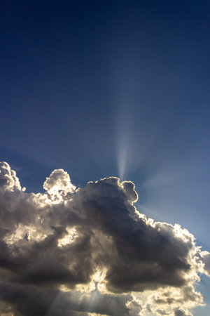 Sun rays through dark clouds on a blue sky. Sun rays through dark clouds.の写真素材