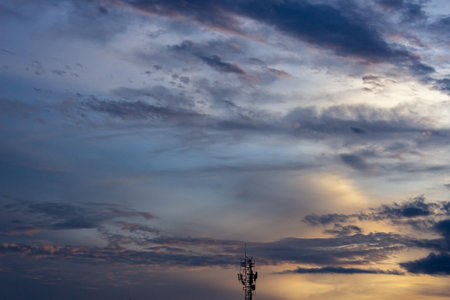 Silhouette of telecommunication tower with sunset sky and cloud.の写真素材