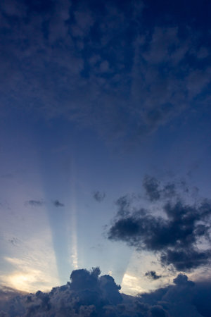 Sunset sky with clouds and rays of light. Natural background.
