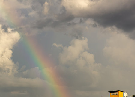 Rainbow in the sky with clouds and rainclouds background.の写真素材