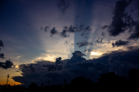 Sunset sky with clouds and rays of light. Beautiful background.の写真素材