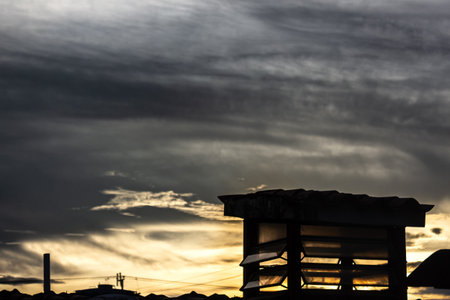 Silhouette of the roof of a house against the sunset skyの写真素材
