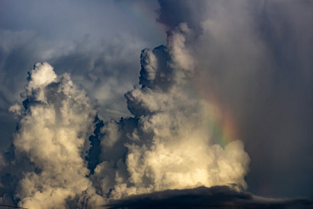 Rainbow in the dark sky with storm clouds. Beautiful nature background.の写真素材