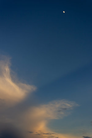 Moon and clouds in the blue sky at sunset. Abstract background.
