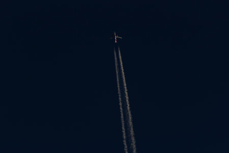 Airplane in the blue sky with white clouds on a black backgroundの写真素材