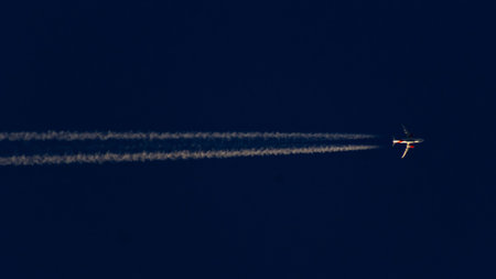 Airplane in the sky with a trail of white smoke.