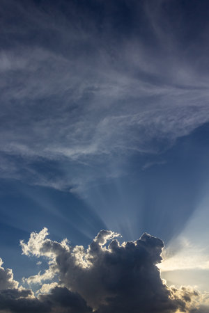 Clouds in the blue sky with sun rays and lens flare.の写真素材