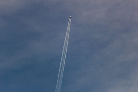 airplane in the blue sky with trace of the contrail.