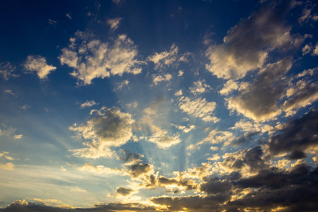 Sunset sky with clouds and sunbeams. Nature background.