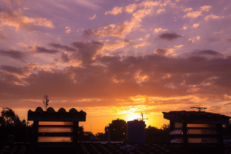 Sunset over the roofs of houses in the city. Sunset backgroundの写真素材