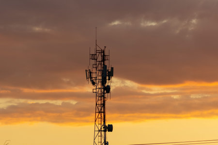 Silhouette of Antenna tower with sunset sky background in the evening.