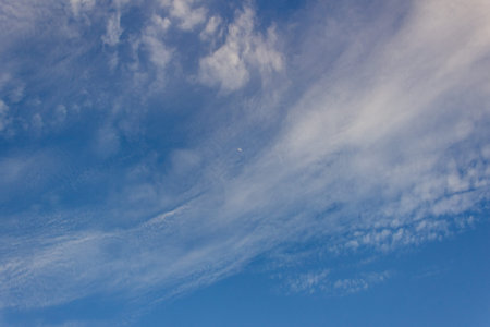 Blue sky background with tiny clouds. White fluffy clouds in the blue sky.