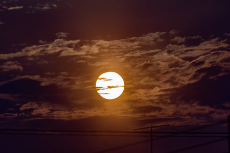 Sunset in the evening sky with clouds. The sun behind the clouds.