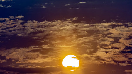 Sunset sky with clouds and the sun. Beautiful nature background.の写真素材