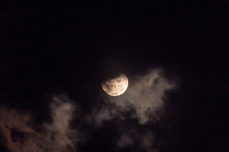 The moon in the night sky in the clouds. Close-up.