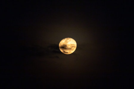 Full moon in the night sky with clouds, closeup of photo