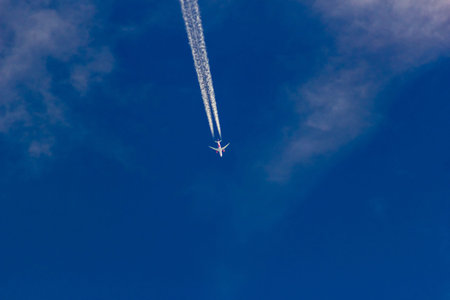 Airplane in the blue sky with white clouds, closeup of photo