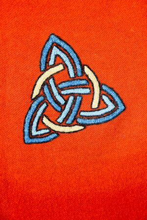 Interlaced triquetra symbol on a red blanketの写真素材