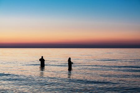 Angler in the evening on the shore of the Baltic Sea の写真素材