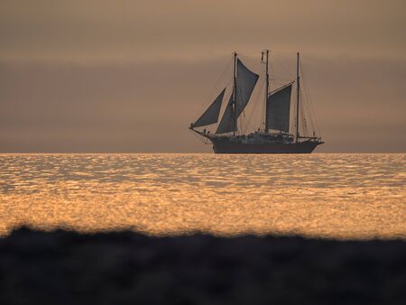 A sailing ship on the Baltic Sea in sunset の写真素材