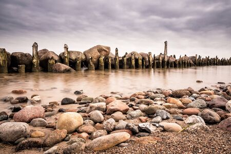 Groynes on shore of the Baltic Sea in the evening.の写真素材