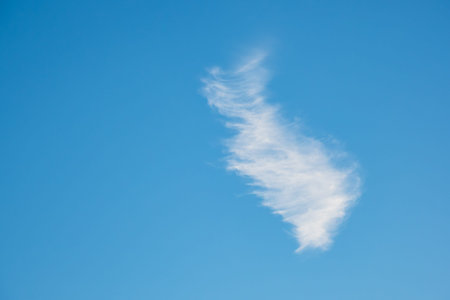 A white cirrus cloud with blue sky.
