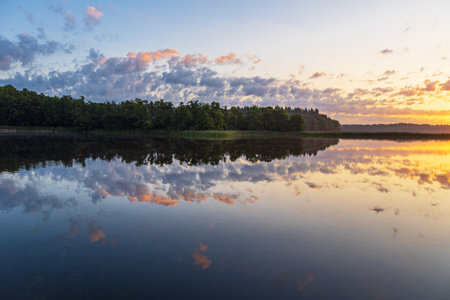 Sunrise with clouds and reflection at the lake Schaalsee in Seedorf, Germany.の写真素材