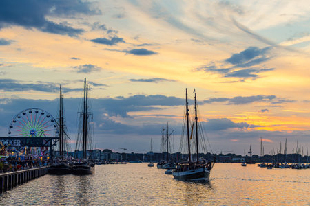 Sailing ships on the river Warnow in the sunset during the Hanse Sail in Rostock, Germany.