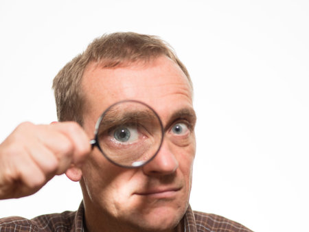 Man looking through magnifying glass
