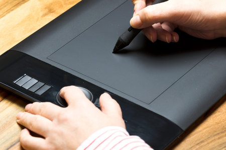 Hand with graphics tablet on a board