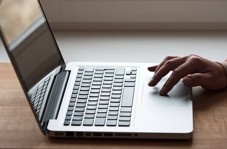 Hand on touchpad of laptop in back lightの写真素材