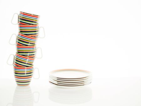 Cup stacking and stack of plates against a white backgroundの写真素材