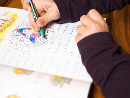 Child writes numbers in a booklet detailの写真素材