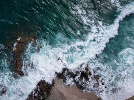 Waves crashing into the rocks of Plaka beach in the Aegean Sea at Pelion Peninsula, Greece. Photo taken with drone.の写真素材