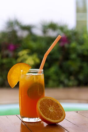 Orange juice and fruit around a swimming poolの写真素材