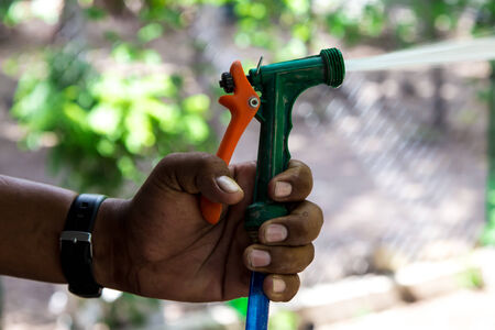 watering the garden, man using hose pipeの写真素材
