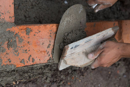 bricklayer. Construction worker using tools to build a brick wallの写真素材
