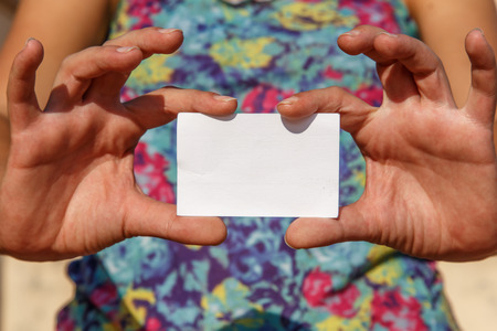 girl showing an empty white cardの写真素材