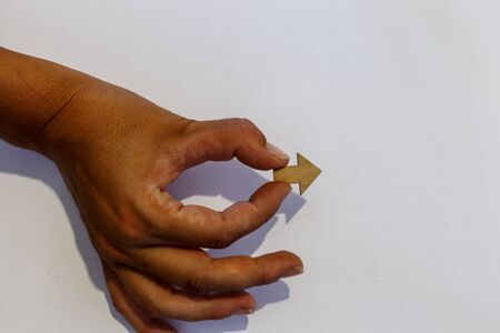Hand holding a small arrow pointing to the rightの写真素材